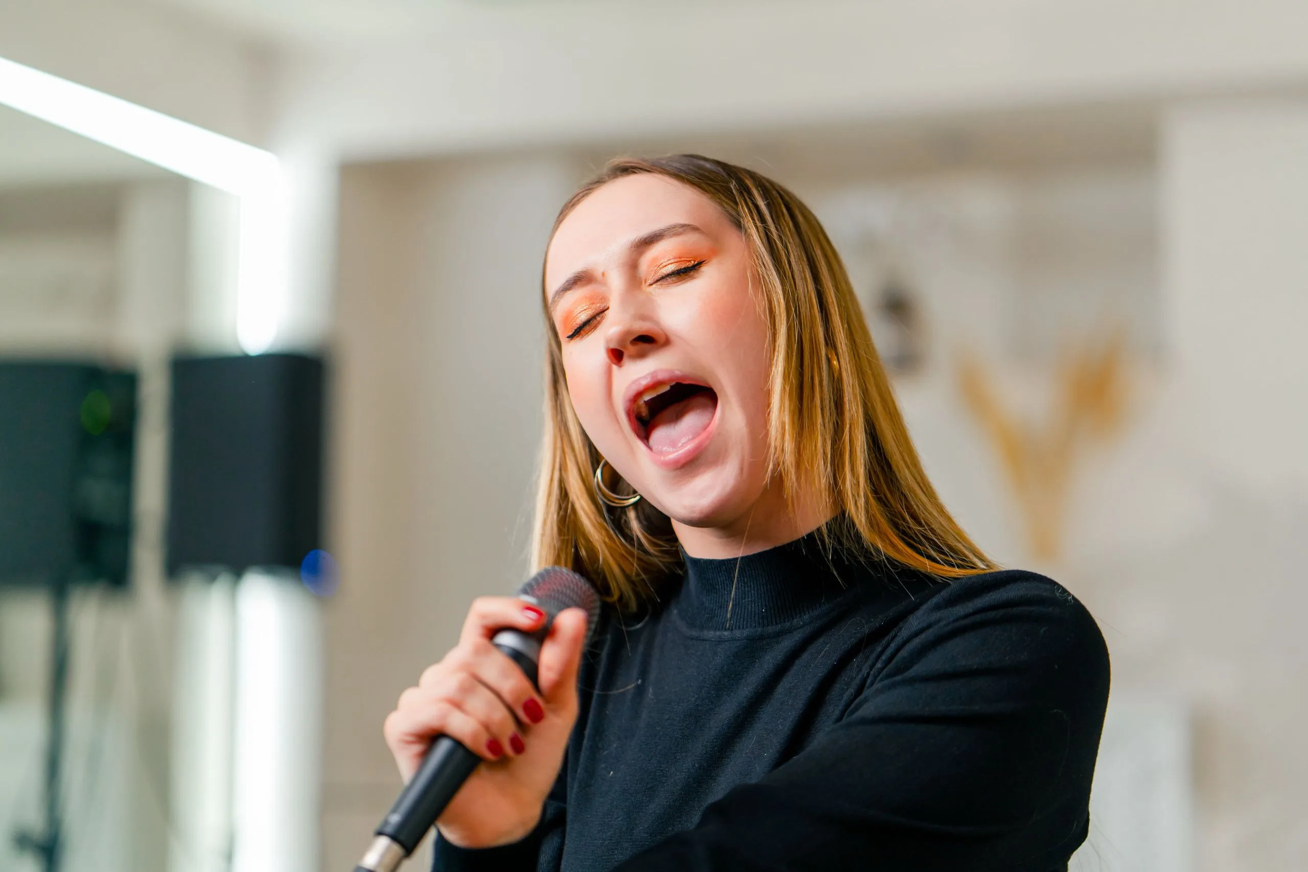 Young girl sings in a vocal lesson with a microphone.
